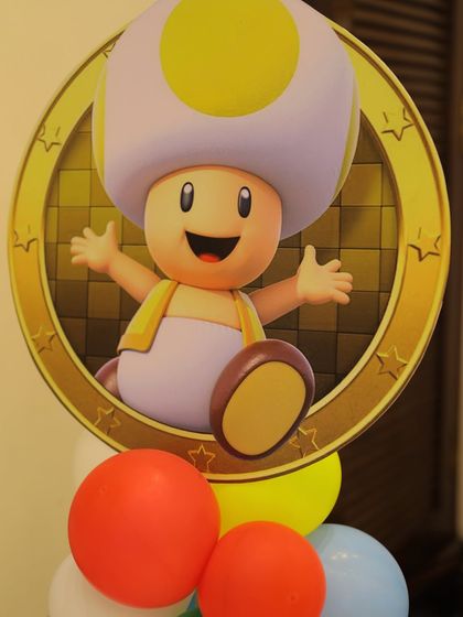 A cute Toad character cutout on top of a colorful balloon pillar. These character accents are perfect for decorating corners or flanking the main stage area.