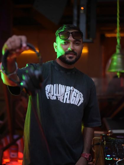 Holding up my headphones, ready for the next mix. This is a classic DJ pose, symbolizing that the work is never done and the next beat is always coming.