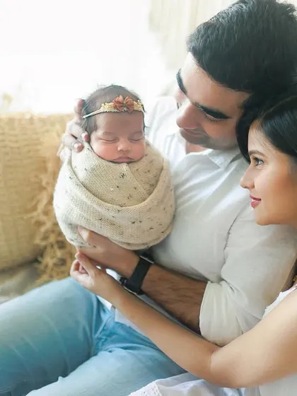 'What we just created'. This beautiful lifestyle shot captures the awe and wonder of new parents as they admire their precious baby girl.