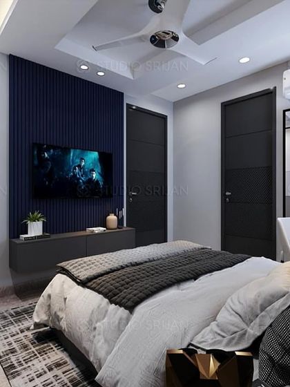 The TV wall in the same bedroom, featuring a fluted blue panel that adds texture and a pop of color to the space.