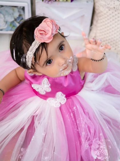 A sweet, upward glance from the birthday girl. Even covered in cake, her charm shines through in this adorable portrait.