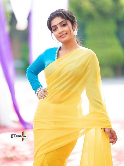 A vibrant shot of a model in a bright yellow saree with a contrasting blue blouse, showcasing a bold and modern take on traditional wear.