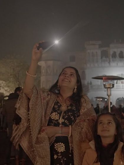 A mother and daughter watch a wedding drone show, their faces filled with wonder. We create moments that are not just for the couple, but for every generation present.