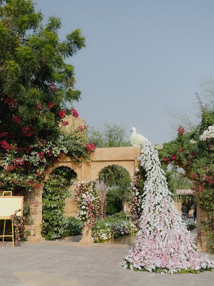 A unique floral peacock with a cascading tail of pink and white flowers served as a stunning centerpiece for this pastel wedding. We designed it to look as if it grew organically from the decor, a signature piece that was uniquely theirs without feeling loud.