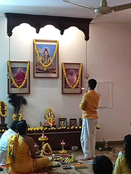 A priest performs arati, the waving of light, before the portraits of our masters, a key part of our daily worship and special ceremonies.