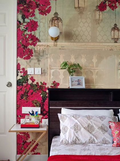 A still from the parents' room, highlighting the intricate wallpaper design behind the headboard. The combination of vibrant florals and soft lighting creates a dreamy and inviting atmosphere.