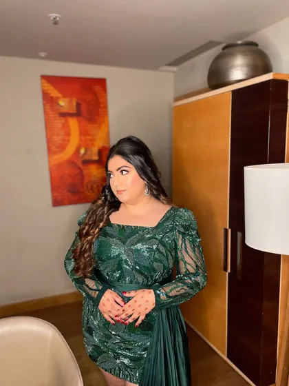 A glam goddess in this green sequin ensemble. This look is all about confidence, with a bold eye, glowing skin, and voluminous curls. Perfect for a night of celebration.