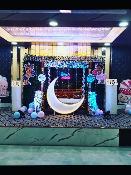 A baby shower stage setup in a hall with marble-patterned walls, demonstrating how the decor can be adapted to different venue styles.