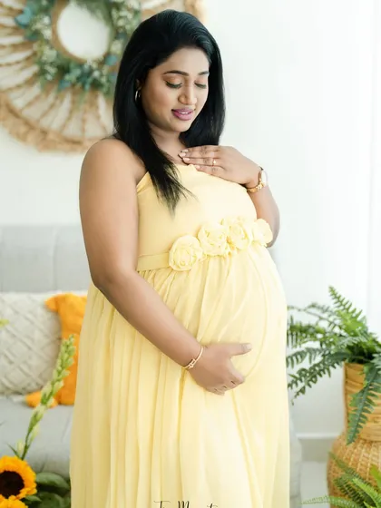 A tender moment of connection, as the mother-to-be holds her bump. The soft lighting and natural setting enhance the feeling of peace.
