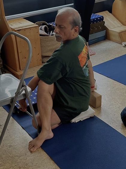 A seated twist, Bharadvajasana, using a chair for support to encourage proper spinal rotation.