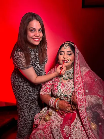 A smiling moment with the bride. The red background adds a dramatic flair to this behind-the-scenes shot.