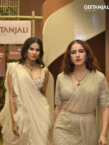 Two models showcasing different but complementary looks at our Ahmedabad launch event. One features a soft, romantic style while the other is more structured and bold, showing our team's range.