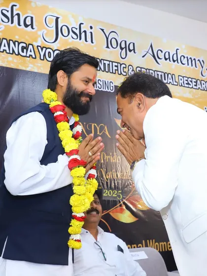 A moment of mutual respect and greeting at the award ceremony in Indore. The spirit of humility and reverence is central to the path of yoga.