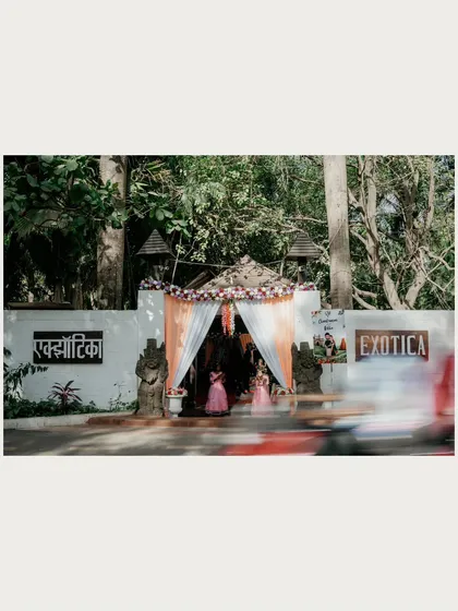 A shot of the wedding venue entrance, using a slow shutter speed to capture the motion of a passing car, adding a dynamic feel to the scene.