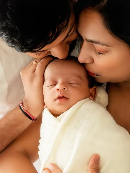 Kisses for the baby from both mom and dad. A portrait overflowing with affection and warmth.