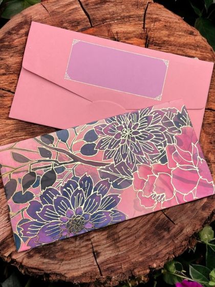 A vibrant pink and purple floral money envelope, perfect for adding a pop of color to your gift.