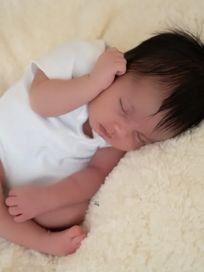 Another angle of the baby sleeping, showing their tiny hands and soft hair. These are the pure, simple moments to cherish.