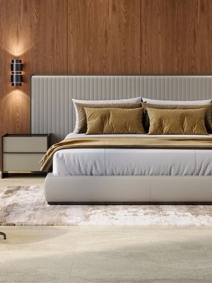 Warmth and texture are key in this minimal bedroom. A wood-paneled accent wall is paired with a comfortable leather armchair and ottoman, creating a perfect corner for reading and relaxing.