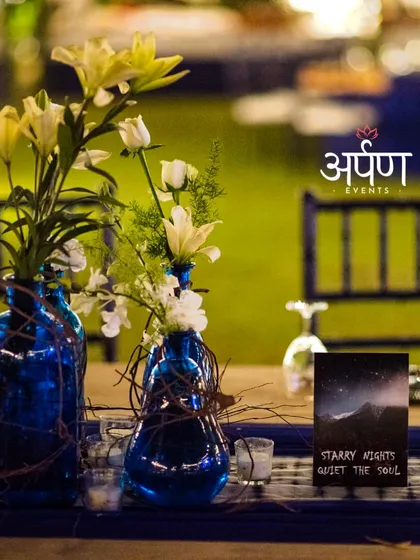 Floral centerpieces in blue vases tie into the event's theme, creating a cohesive and visually appealing dining experience.