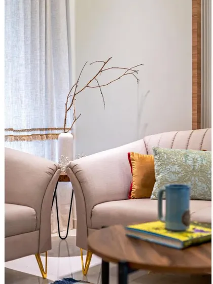A detail shot of the side table and decor, where a simple branch in a vase adds a sculptural, natural element. We believe in the power of simple, thoughtful styling.