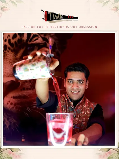 A bartender pours a rich red cocktail, showcasing the beautiful colors of our signature drinks.