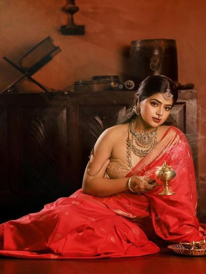 A regal portrait series inspired by the queens of Tulunadu. The model is adorned in a stunning red saree and antique-style jewelry, captured in a heritage location to enhance the royal theme.