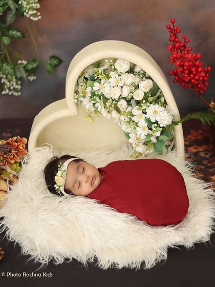 A wider view of the heart-themed newborn shoot, showcasing the full arrangement with soft fur and botanical elements.