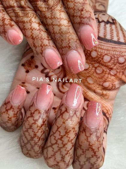 A soft airbrush ombre with a galaxy glitter topper. This is a beautiful and subtle choice for a bride, shown here complementing the intricate henna design.