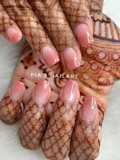 A soft airbrush ombre with a galaxy glitter topper. This is a beautiful and subtle choice for a bride, shown here complementing the intricate henna design.