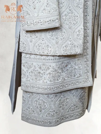 Another detail of the layered embroidery on a white sherwani, showcasing the precision and artistry of the handwork.