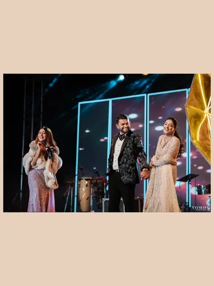A candid moment on the Sangeet stage, capturing the couple's happy interaction with a performer.