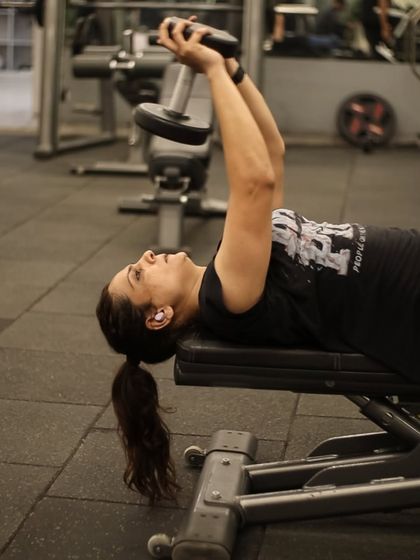 Lying on a bench, this member performs a dumbbell pullover, an effective exercise for working the chest and lat muscles.