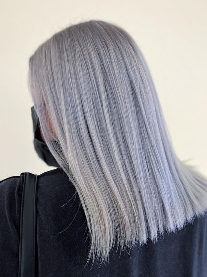 A global application of ash gray hair color. This look is sleek, modern, and makes a powerful statement.