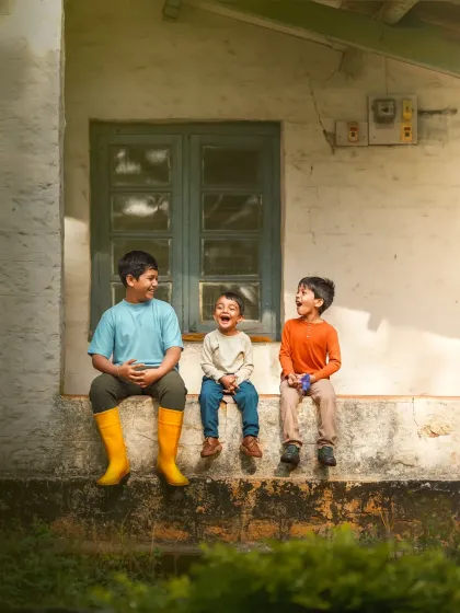 A Rakshabandhan special, celebrating the bond between siblings. This image of three brothers sharing a laugh on a porch is full of warmth and genuine affection.