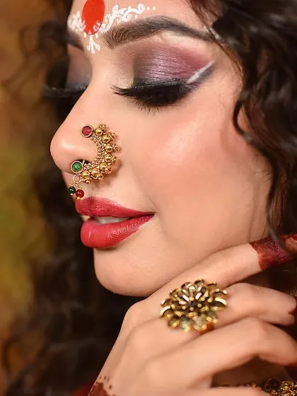 Another portrait from the Durga Puja series, this one with a softer, more demure expression. The focus is on the intricate eye makeup and traditional jewelry, perfect for a beauty or festive campaign.