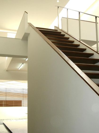 The clean lines of a staircase at the Zanav Home Studio, designed in 2005. The design uses simple geometry and a restrained palette of white walls and wood treads to create a sense of calm and order.