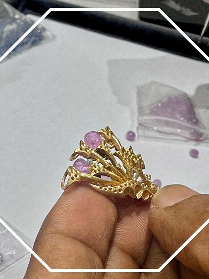 Craftsmanship is also about bringing color to life. In this shot, you can see our artisan carefully setting pink gemstones into a unique, branch-like gold structure. This behind-the-scenes look shows the precision required to handle delicate stones and create a balanced, artistic design.