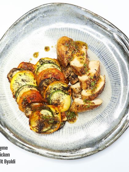 A Mediterranean Plate: Lemon Thyme Grilled Chicken with Confit Byaldi: This dish features tender grilled chicken with a zesty lemon-thyme marinade, paired with Confit Byaldi, a sophisticated version of ratatouille with slow-cooked, thinly sliced vegetables.