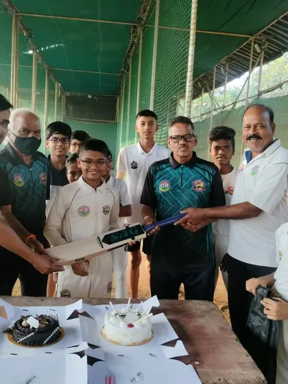 Gifting a new bat to Parth on his birthday, surrounded by his teammates and coaches.