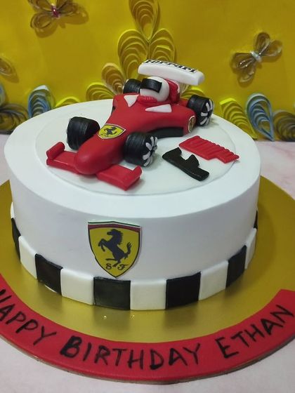 A sleek Ferrari-themed cake for a racing fan. The cake features the iconic red car, checkered flag details, and the Ferrari logo.