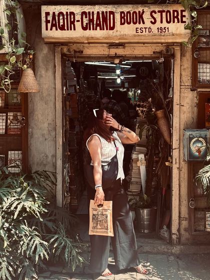 A moment of escape at a vintage bookstore. My outfit, featuring a white top and black wide-leg pants, has a timeless quality that fits perfectly with the nostalgic atmosphere.