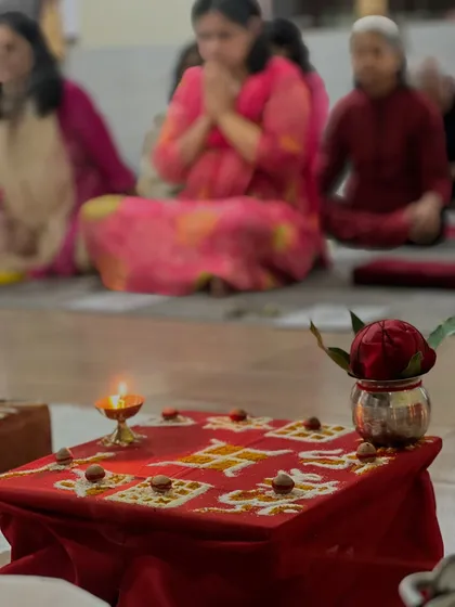A sacred Swastika symbol prepared on the altar, with participants meditating in the background. Yoga is a vast science of spirituality, and these rituals are a part of that tradition.