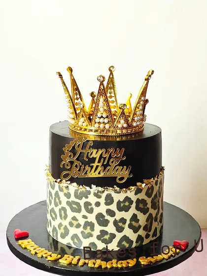 A fierce and fabulous birthday cake with a leopard print bottom tier and a sleek black top tier, crowned with a golden tiara.