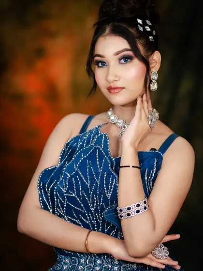A confident portrait that captures the sparkle of the jewelry and the dress, complemented by a glamorous makeup look.