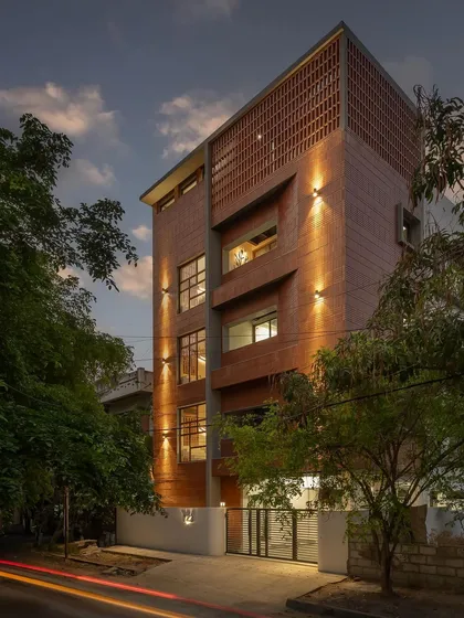 The facade of Project 723 comes alive at dusk. We used linear Baliapatanam bricks in varied arrangements, including a jaali screen pattern on the upper level. Strategic exterior lighting highlights the texture of the brickwork and the building's strong geometric form, creating a captivating presence on the street.