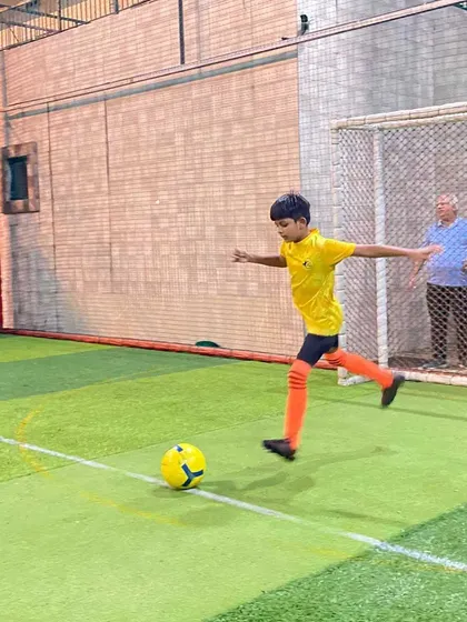 Practice makes perfect. A young player is captured mid-kick, focusing on his shooting form during a training session on the turf.