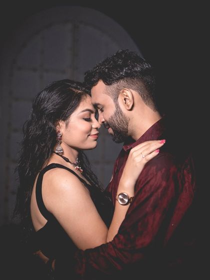 A classic and intimate close-up portrait of the couple, with soft lighting that highlights their connection.