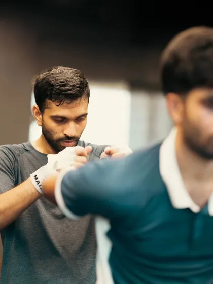 A student focuses on wrapping his hands correctly before a session.