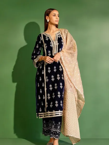 A studio shot of the navy blue velvet kurta set. The contrast with the light pink organza dupatta is just beautiful.