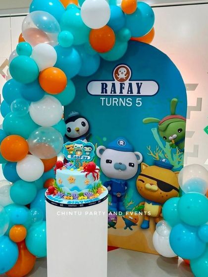 An Octonauts themed 5th birthday party. The underwater-themed backdrop is framed by a teal, orange, and white balloon arch, perfect for fans of the show.